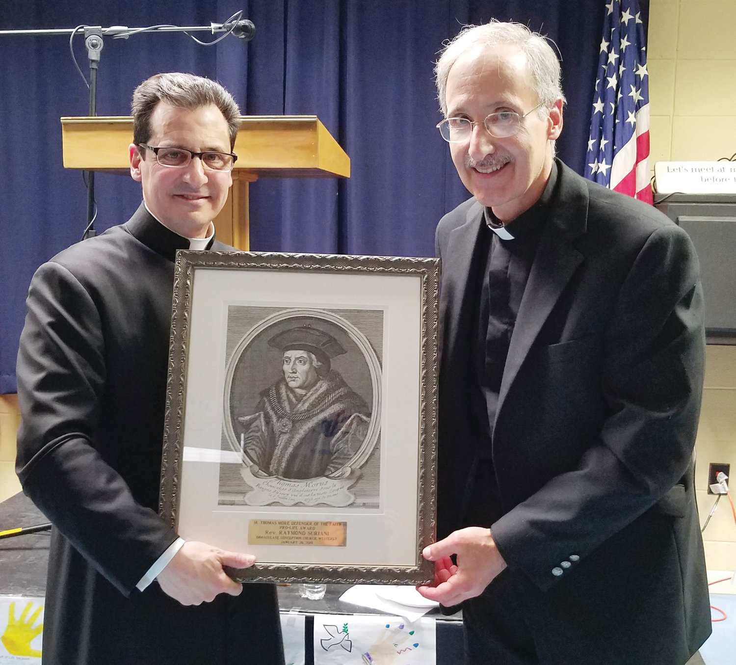 Father Giacomo Capoverdi, left, pastor of Immaculate Conception Church, presents Father Ray Suriani, pastor emeritus of St. Pius X Parish, the St. Thomas More Defender of the Faith Pro-Life award because of his commitment to pro-life issues for more than four decades.